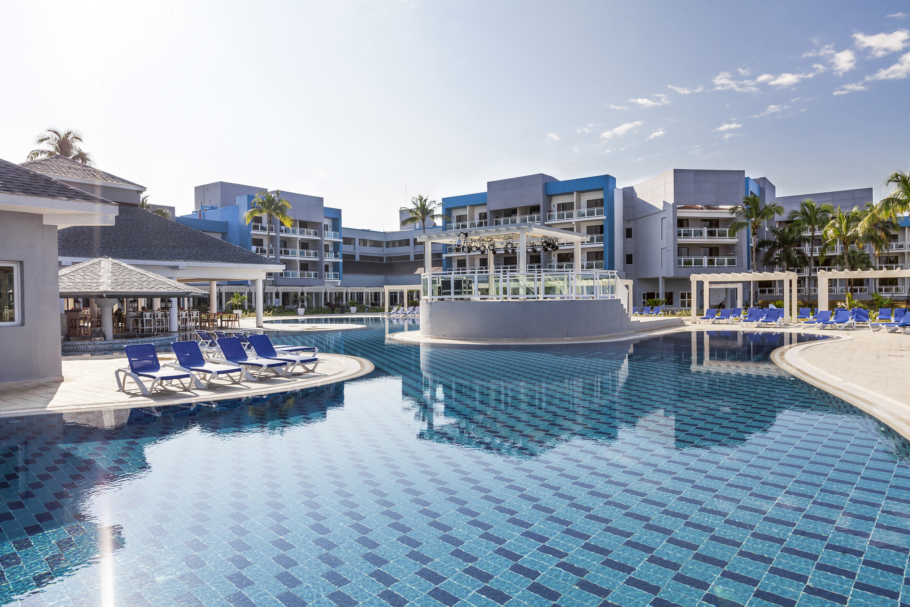 a pool with lounge chairs and a building in the background