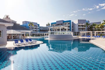 a pool with lounge chairs and a building in the background