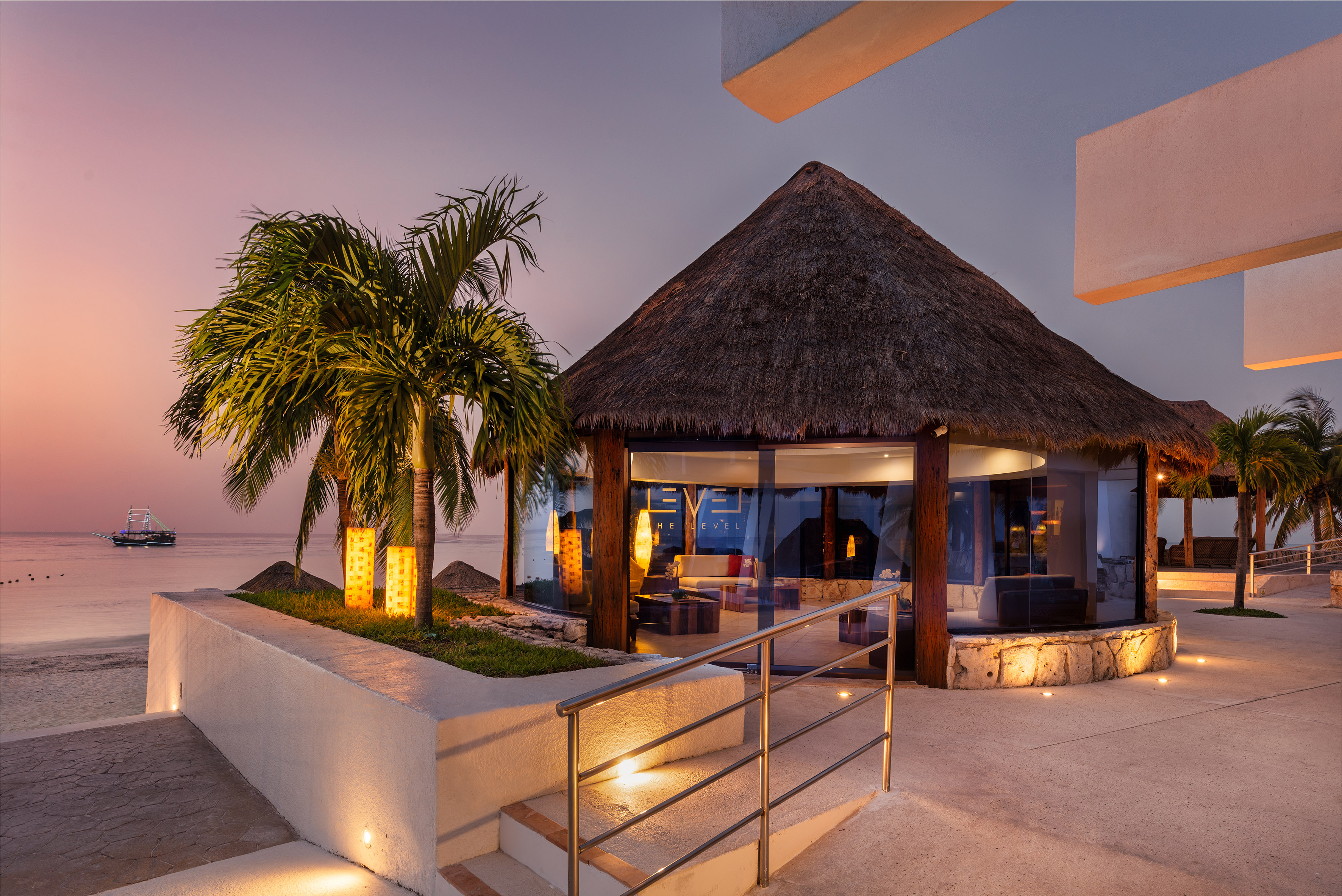 Deixe-se levar por um mundo de distinção e comodidades exclusivas a building with a thatched roof and palm trees