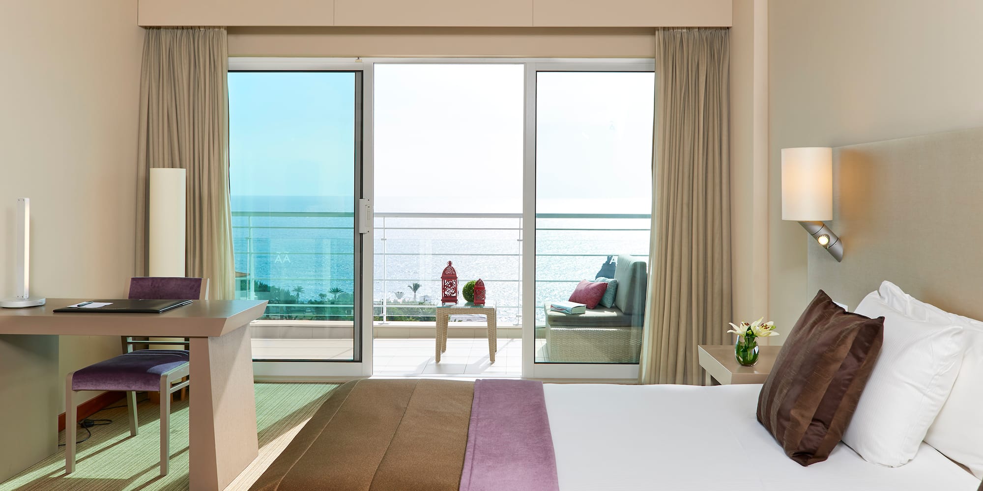 a bedroom with a large window overlooking the ocean