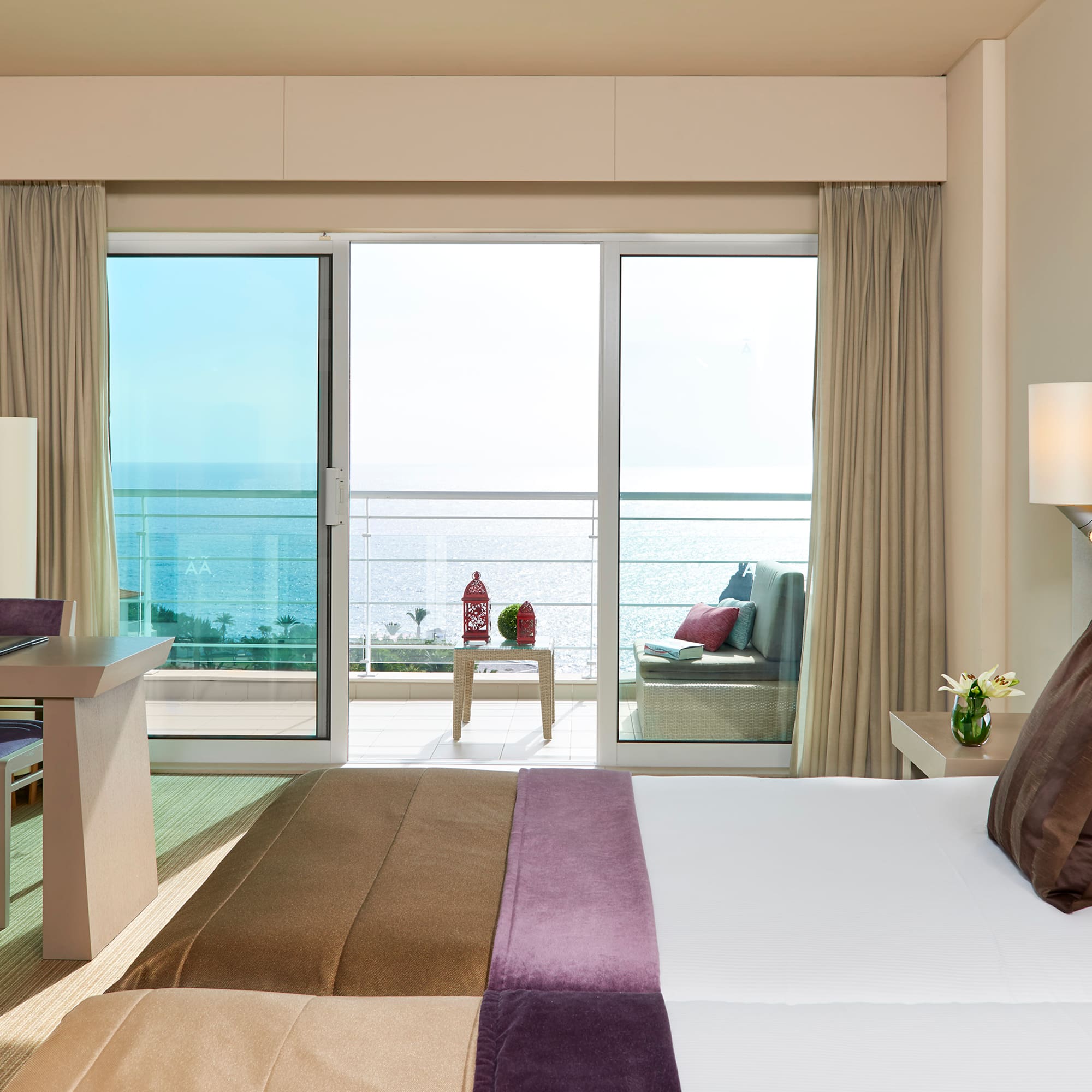 a bedroom with a large window overlooking the ocean
