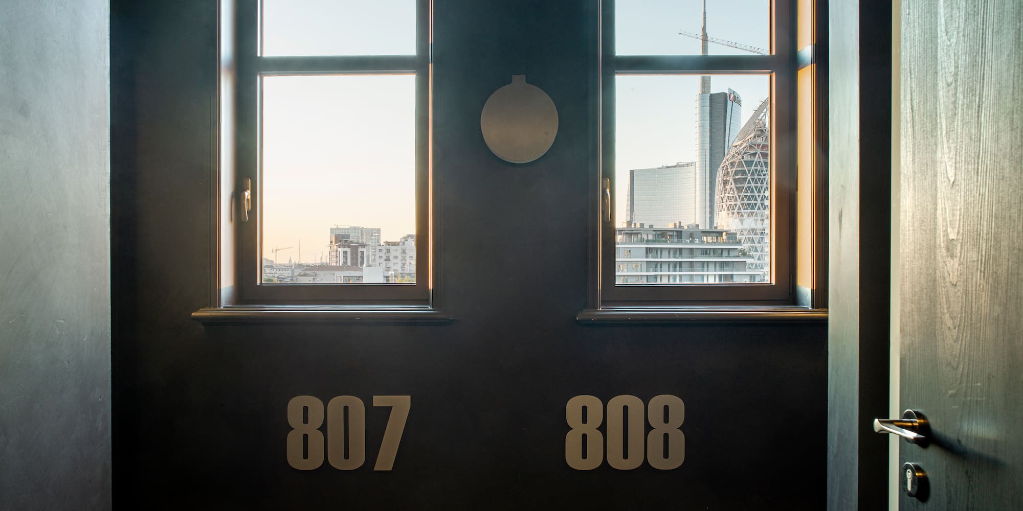 a room with two windows and a city view