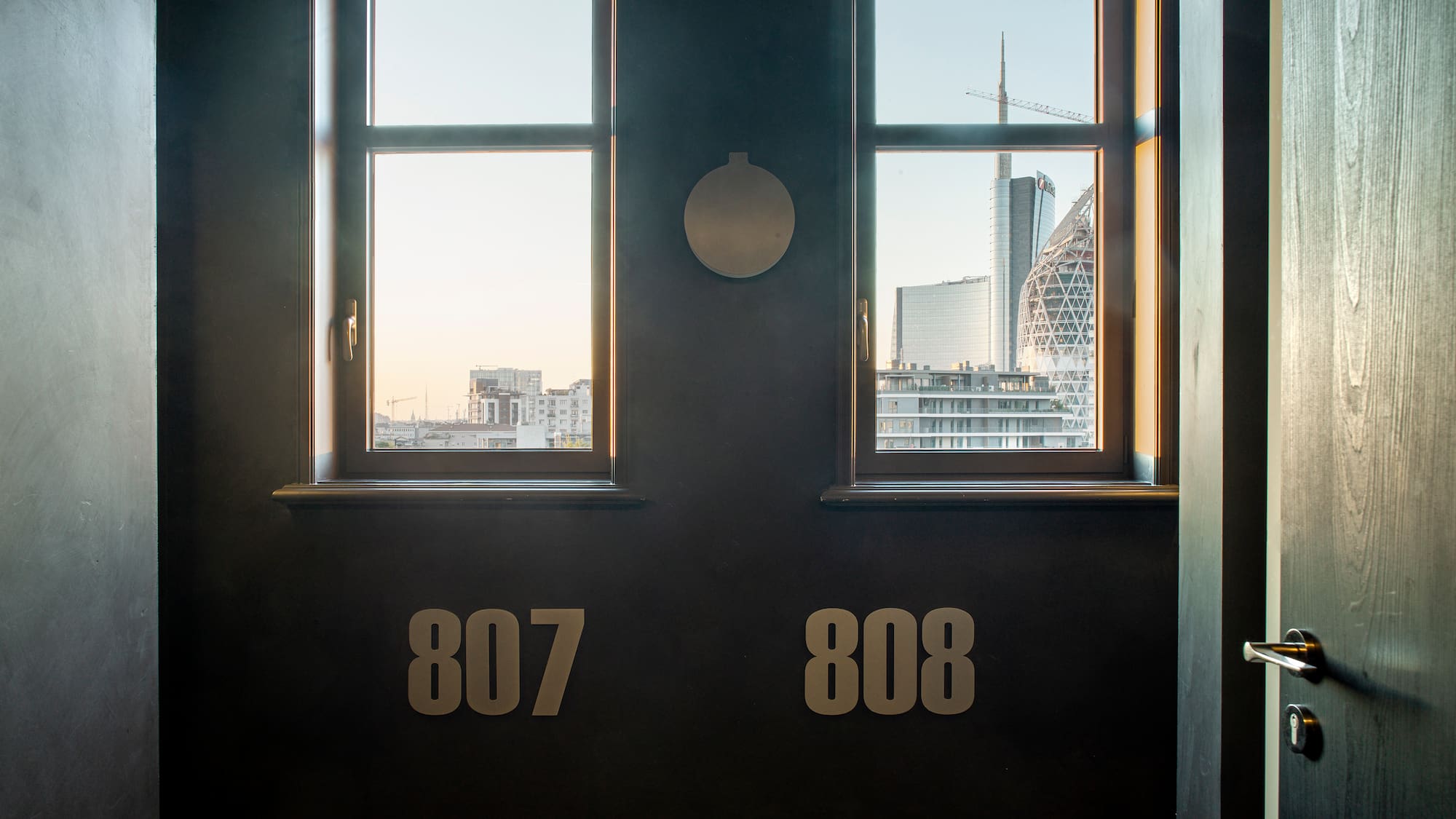 a room with two windows and a city view