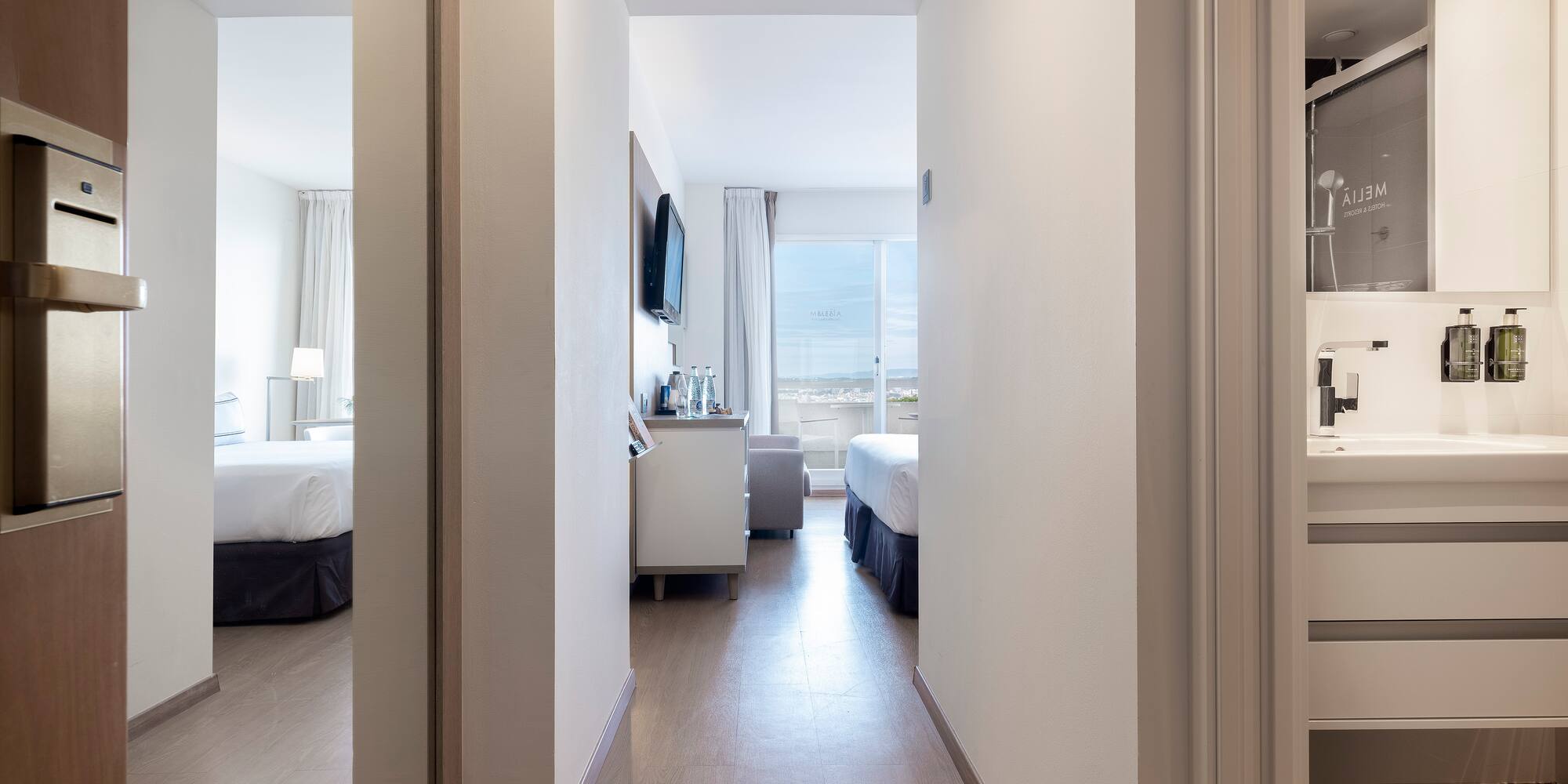 a hallway with a mirror and a bed