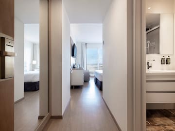 a hallway with a mirror and a bed