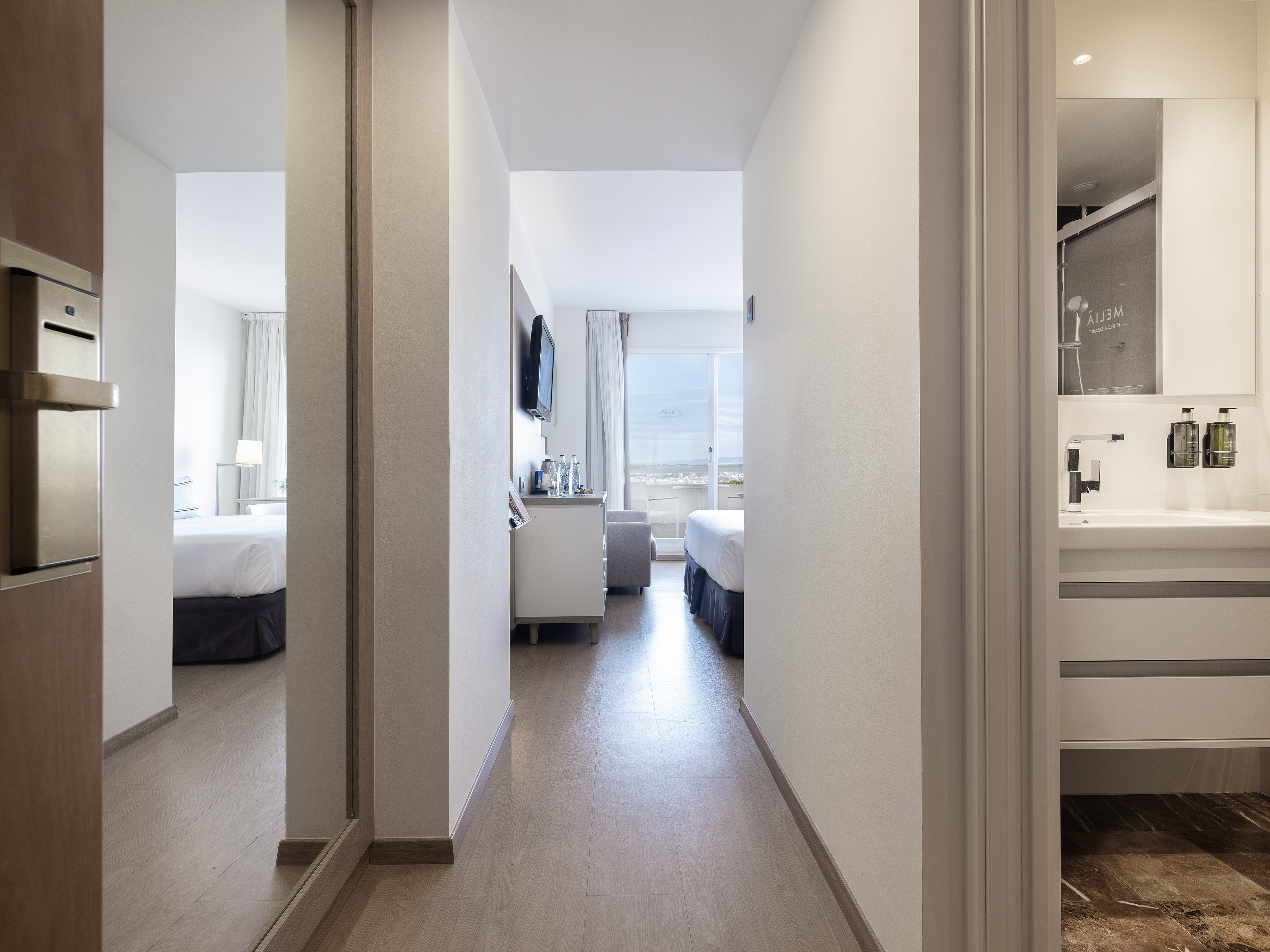 Modern Meliá hotel suite hallway connecting bedroom and bathroom.