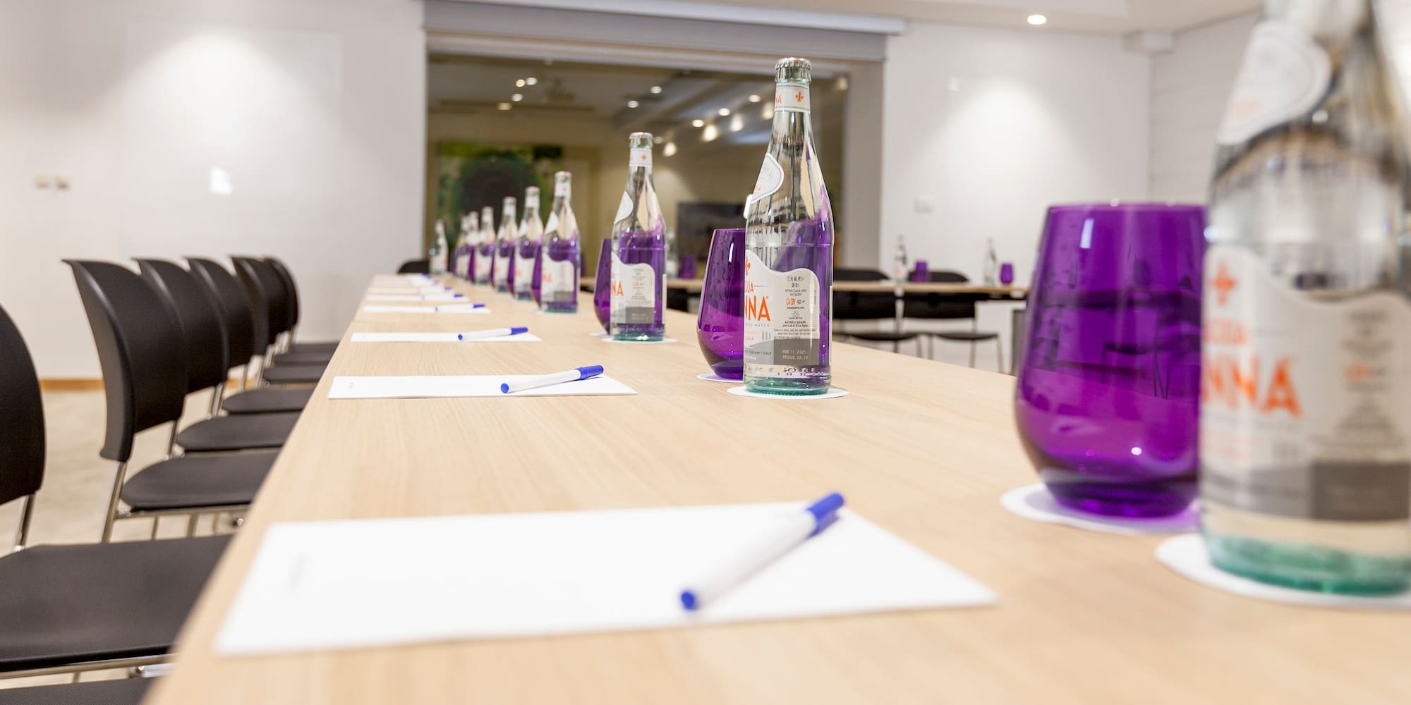 a row of purple glasses and bottles on a table