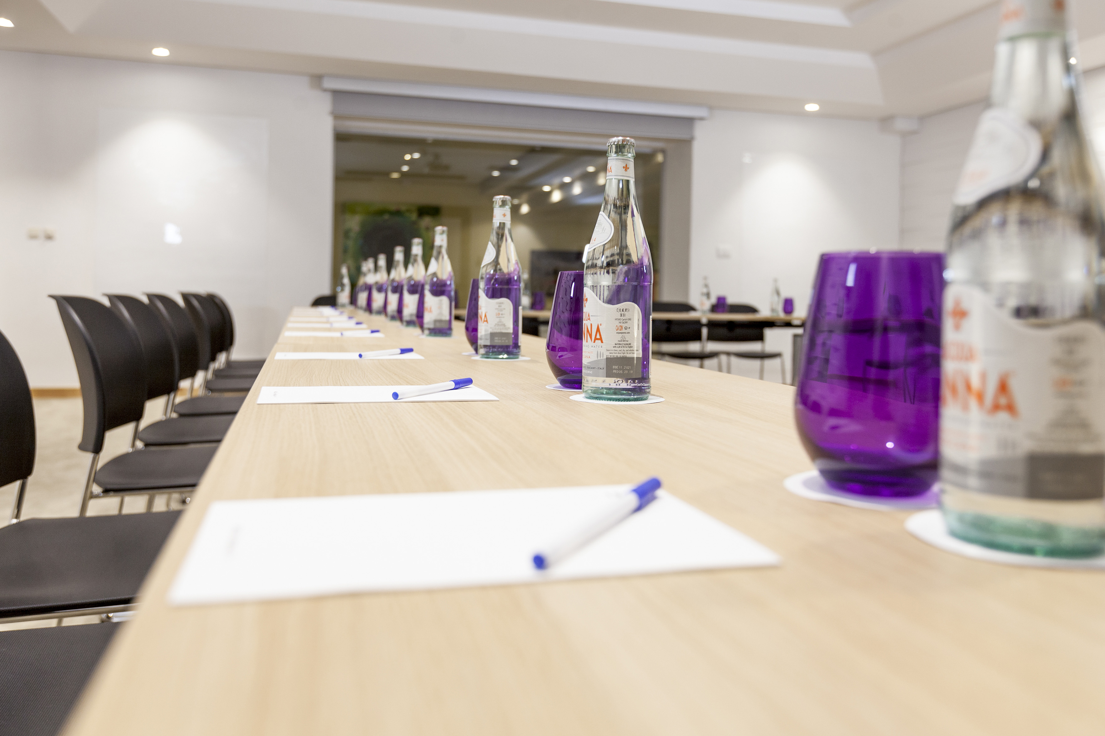 a row of purple glasses and bottles on a table