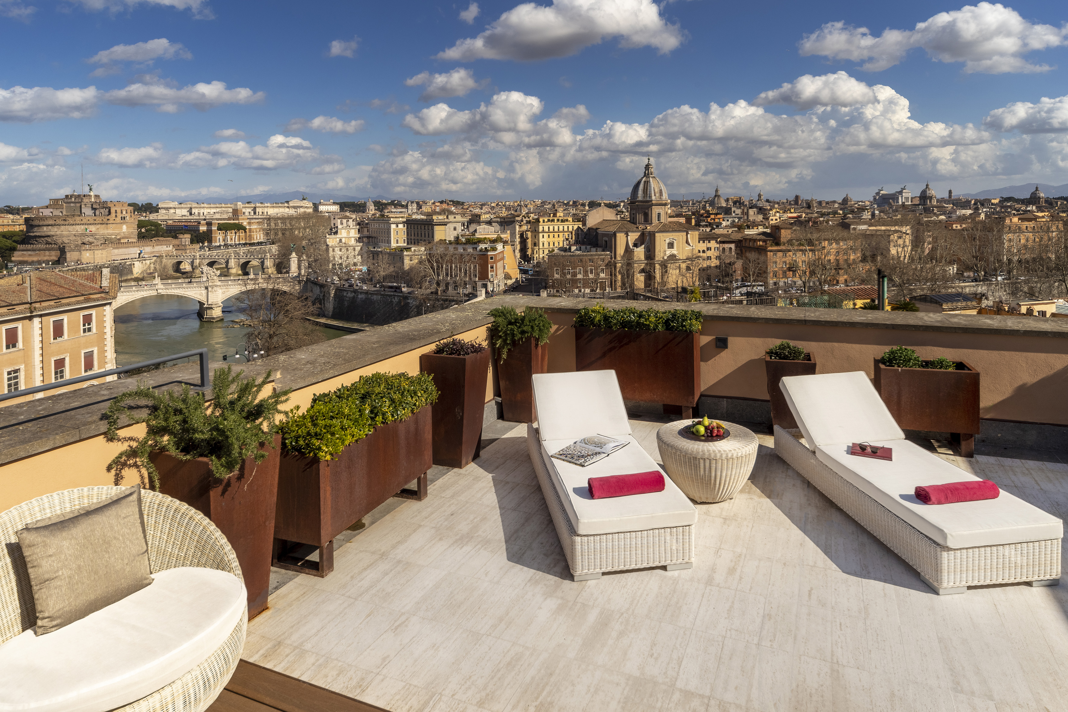 Rome rooftop terrace with Castel Sant'Angelo, Tiber River, and city skyline view.