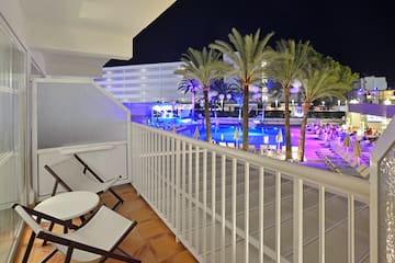 a balcony with chairs and palm trees
