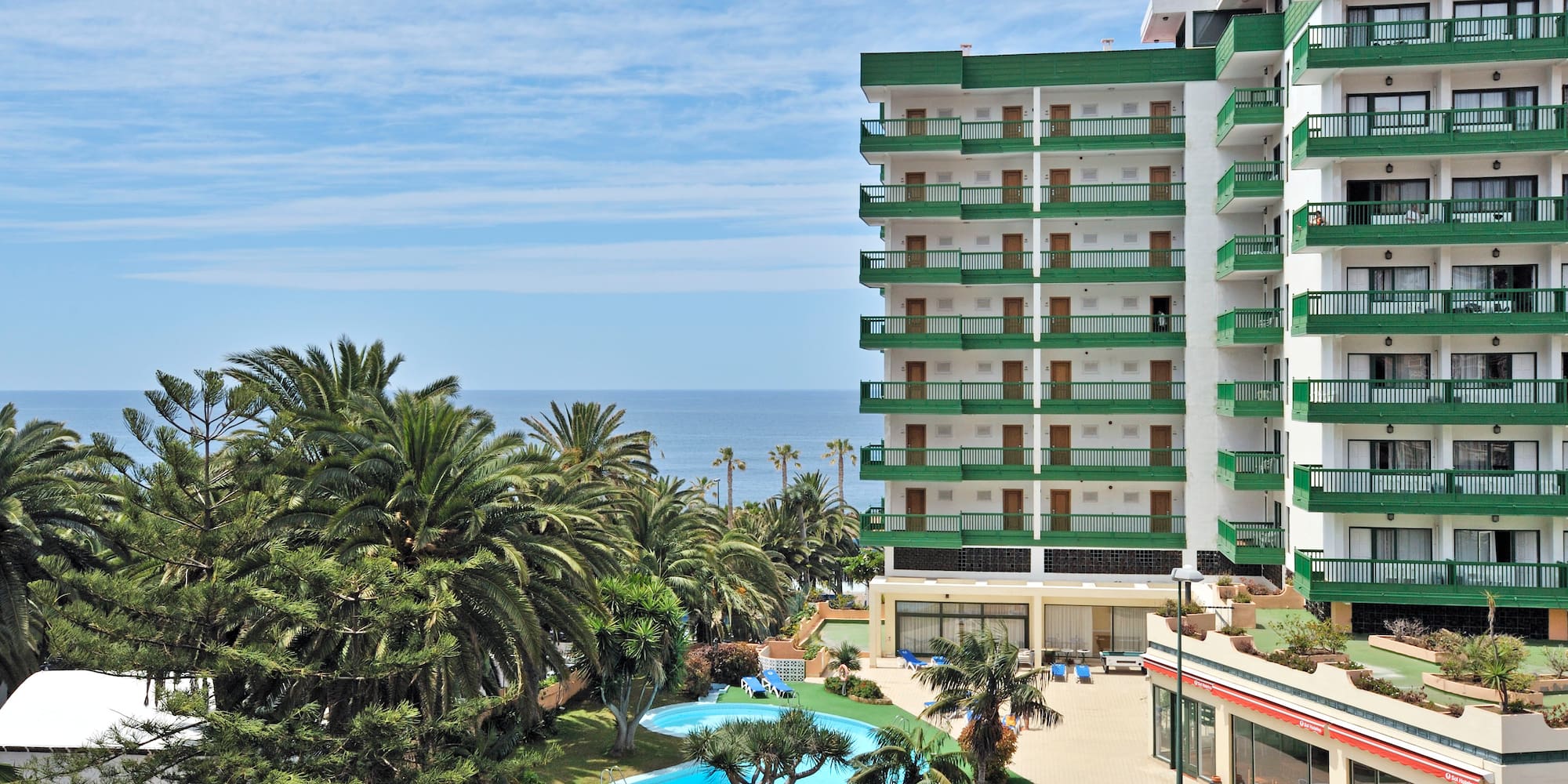 a building with a pool and palm trees