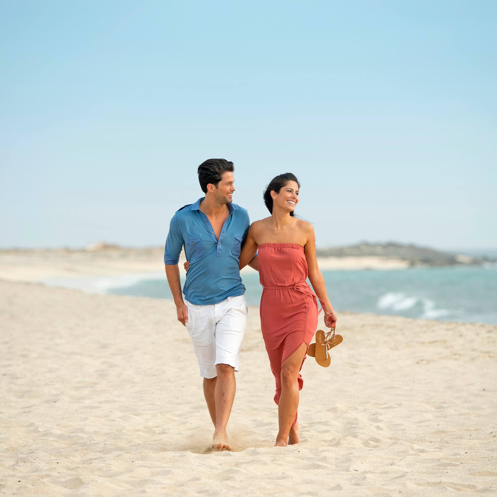 a man and woman walking on a beach