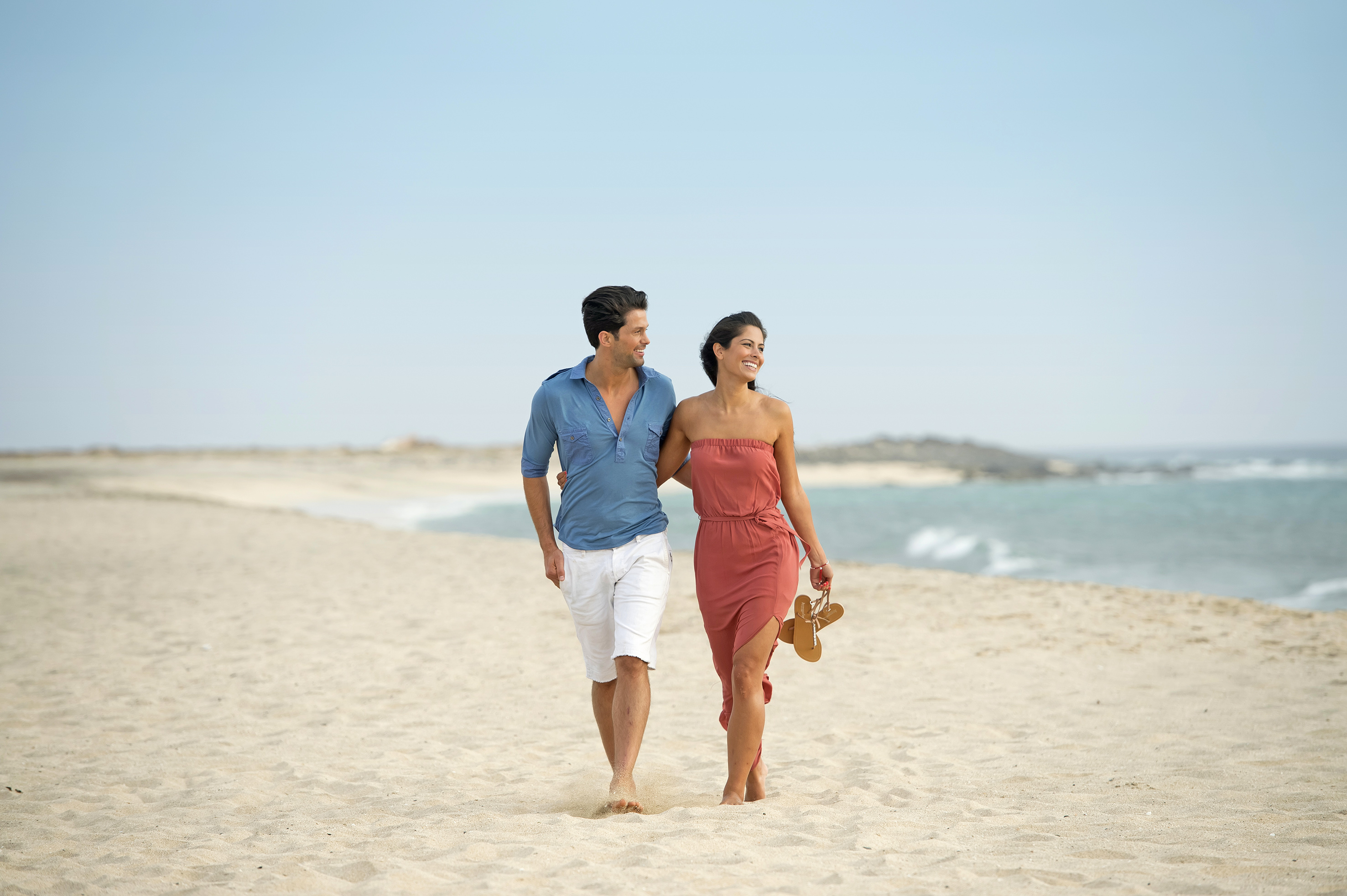 a man and woman walking on a beach