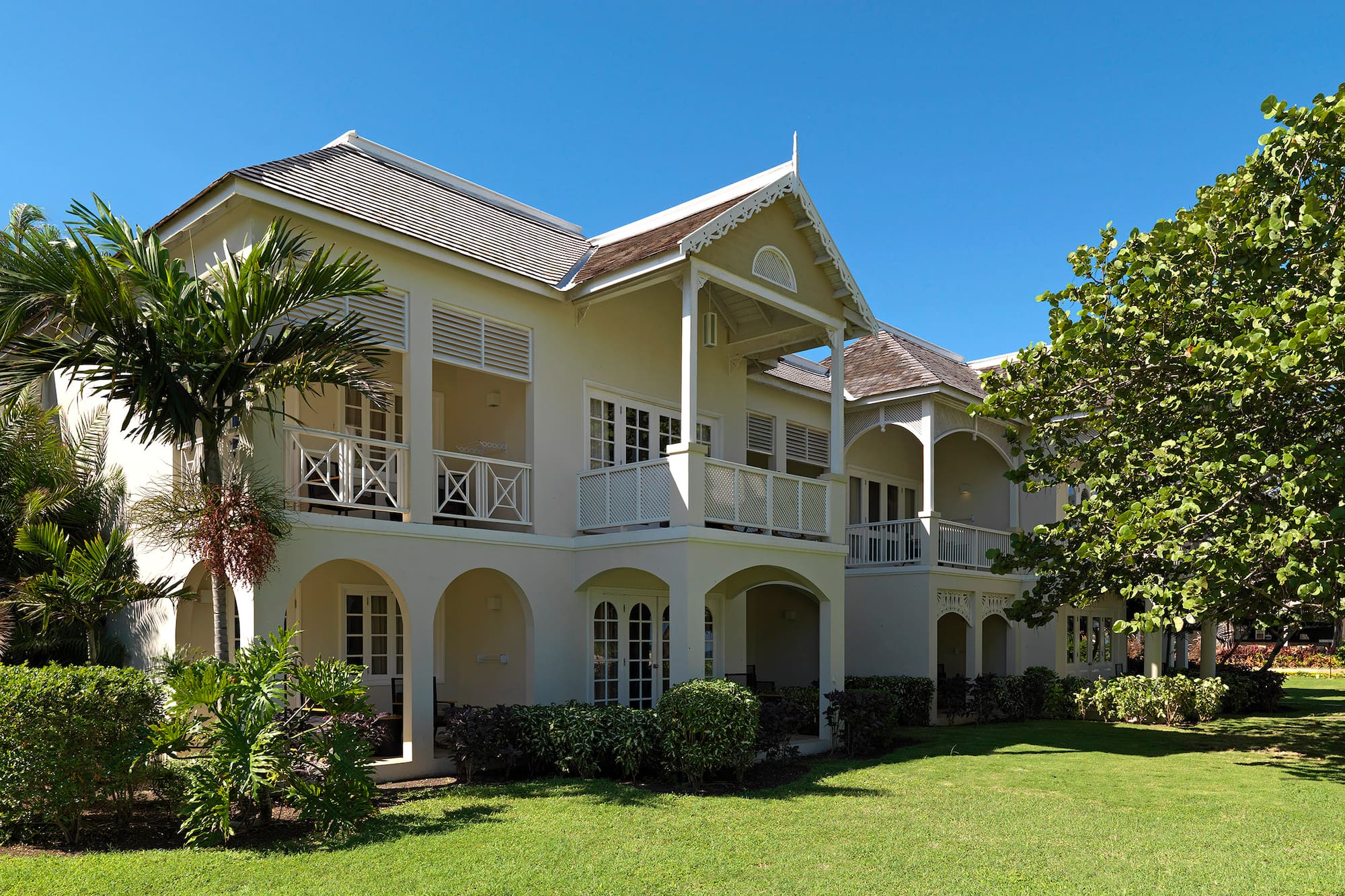 a building with a lawn and palm trees