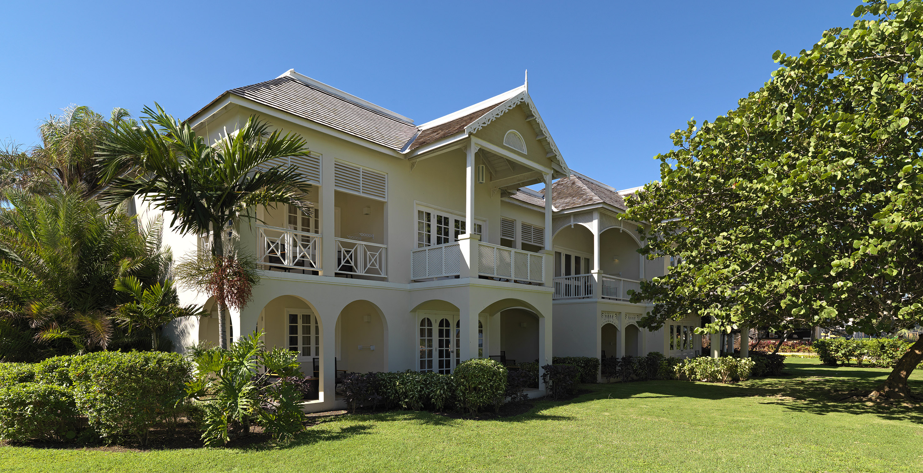 a building with a lawn and palm trees