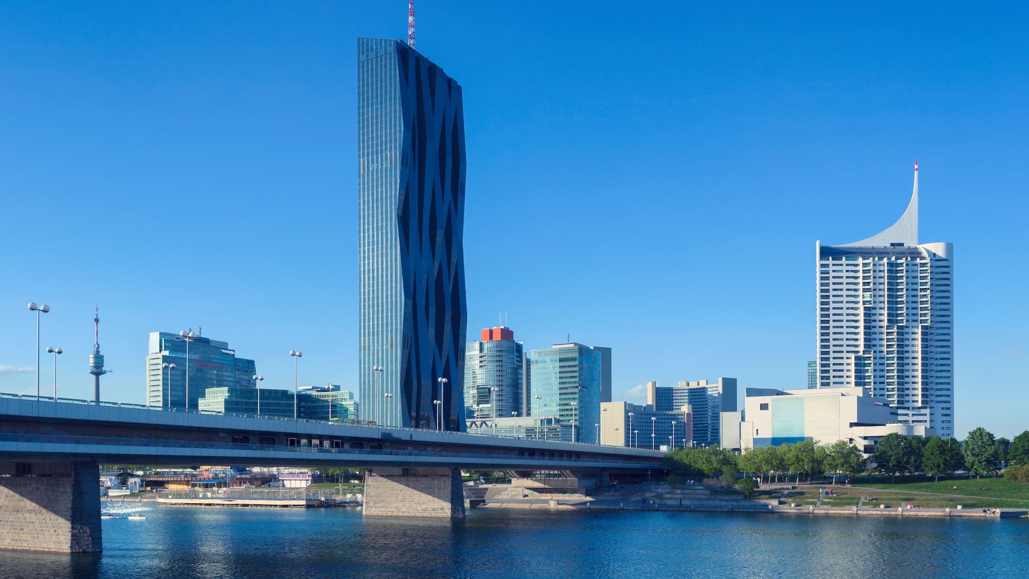 a bridge over water with a tall building in the background