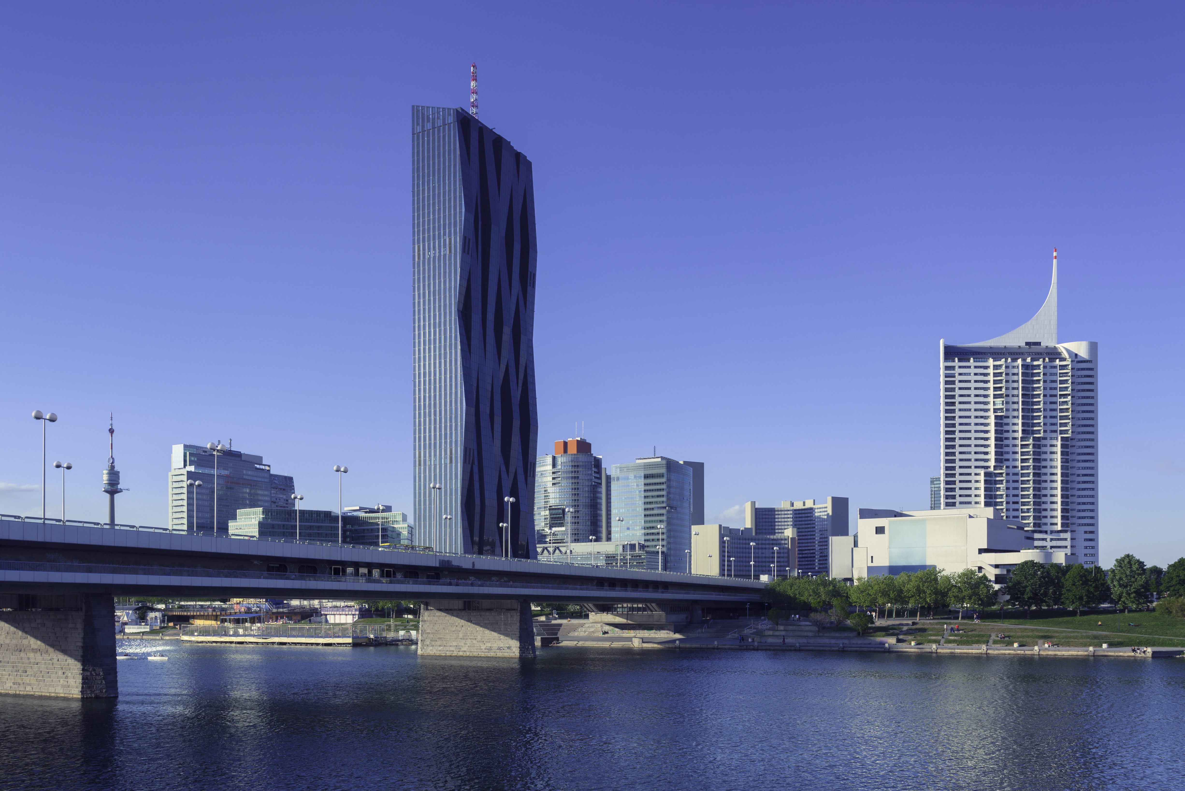 a bridge over water with a tall building in the background