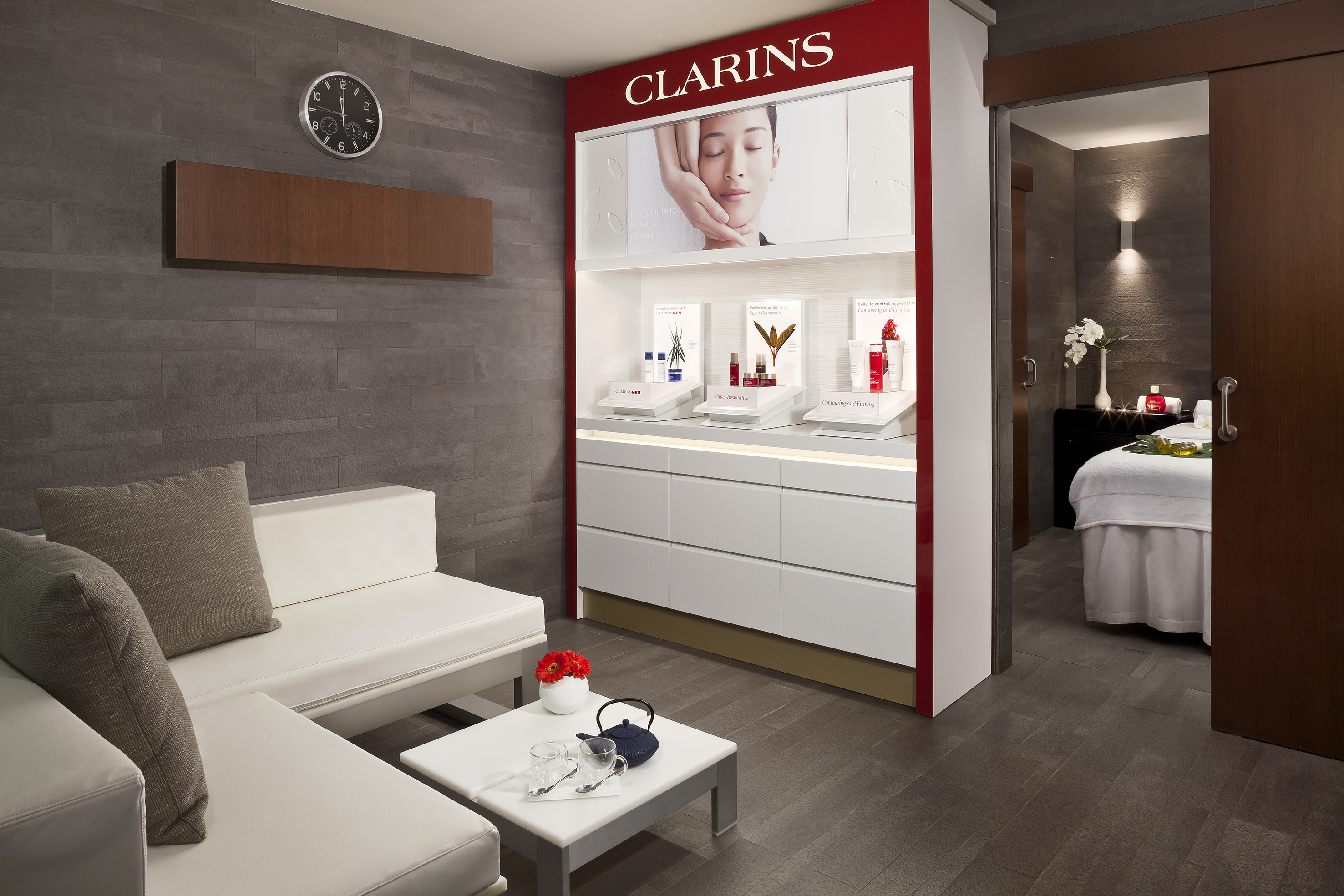 Clarins skincare display, elegant spa lounge, and treatment room entrance.
