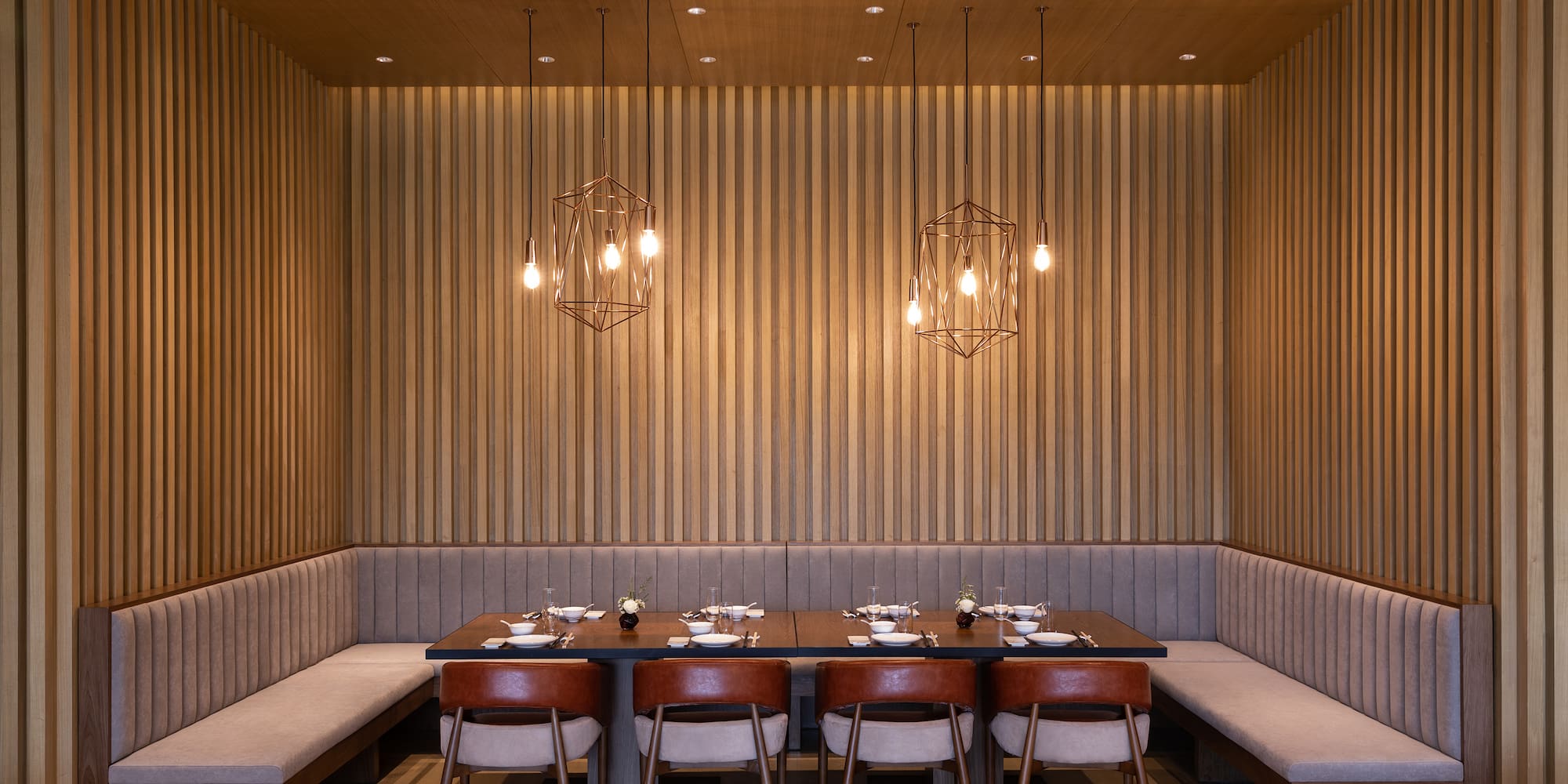 a table with plates and chairs in a room with wood paneling