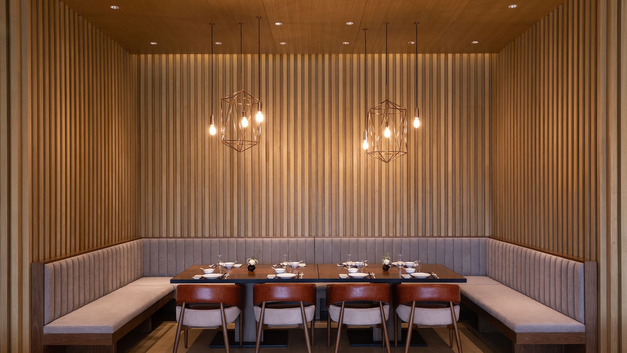 a table with plates and chairs in a room with wood paneling