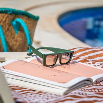 a book and sunglasses on a beach chair