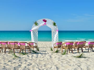a beach with chairs and a archway