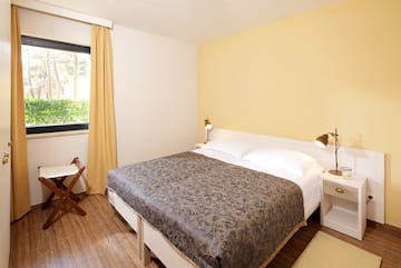 a bed with two lamps and a chair in a room