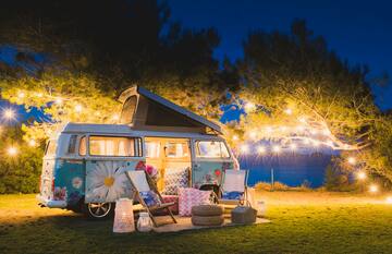 a camper van with chairs and lights