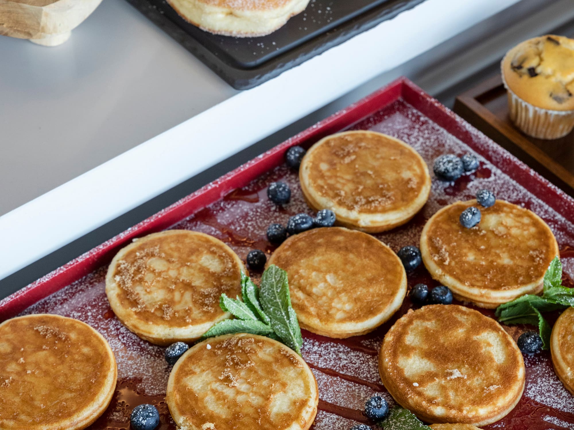 a pancake with blueberries and mint leaves on a tray