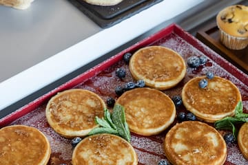 a pancake with blueberries and mint leaves on a tray