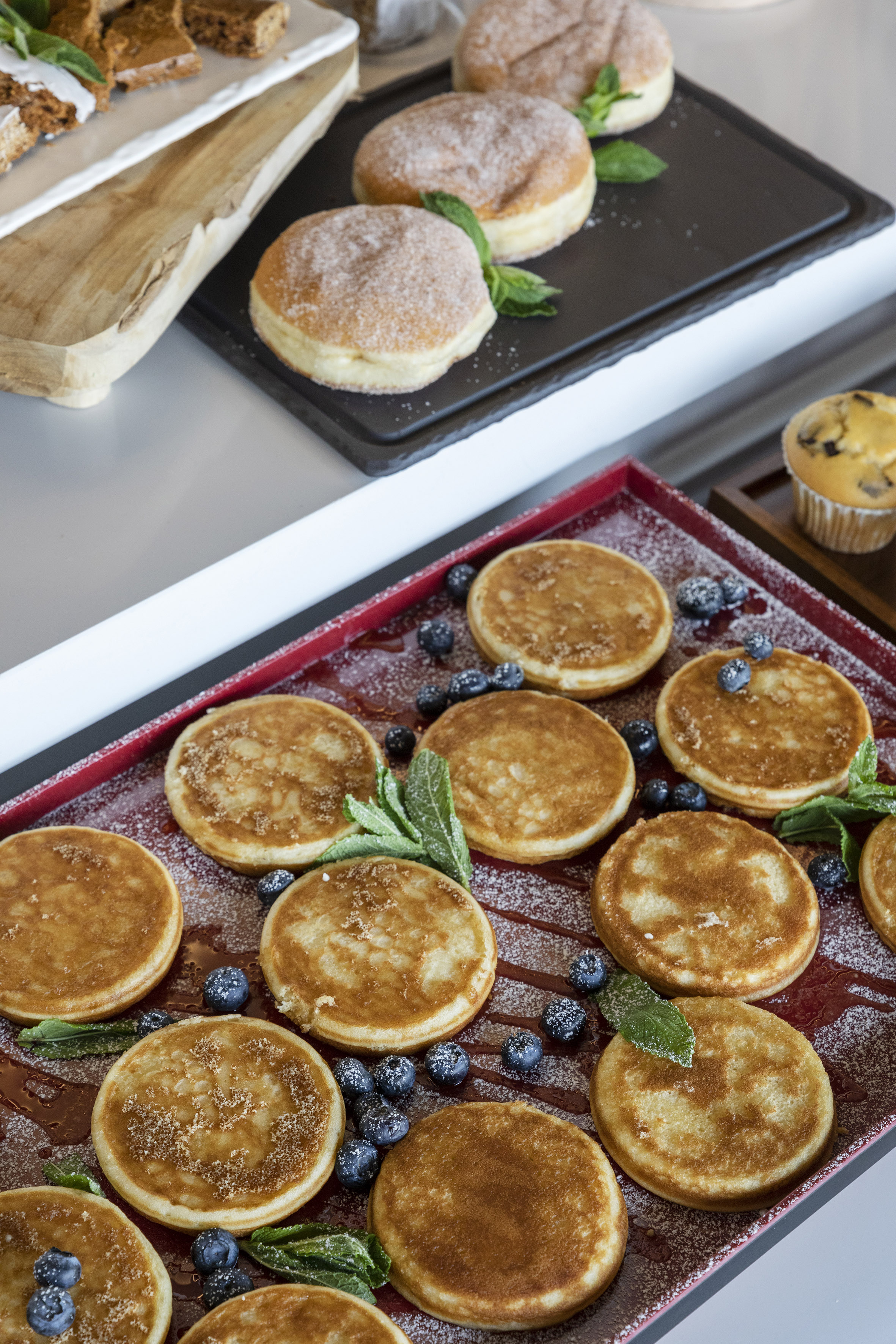 a pancake with blueberries and mint leaves on a tray