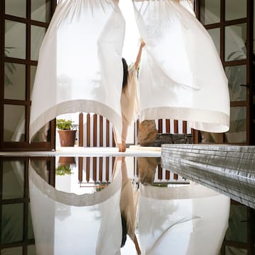 a woman holding a curtain