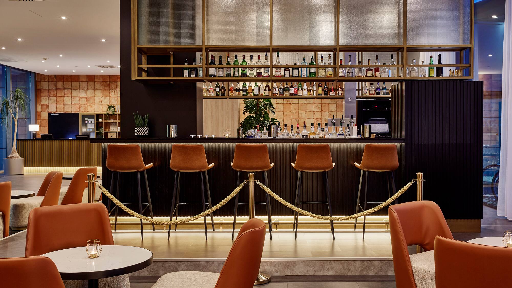 a bar with chairs and a bar with a rope around it