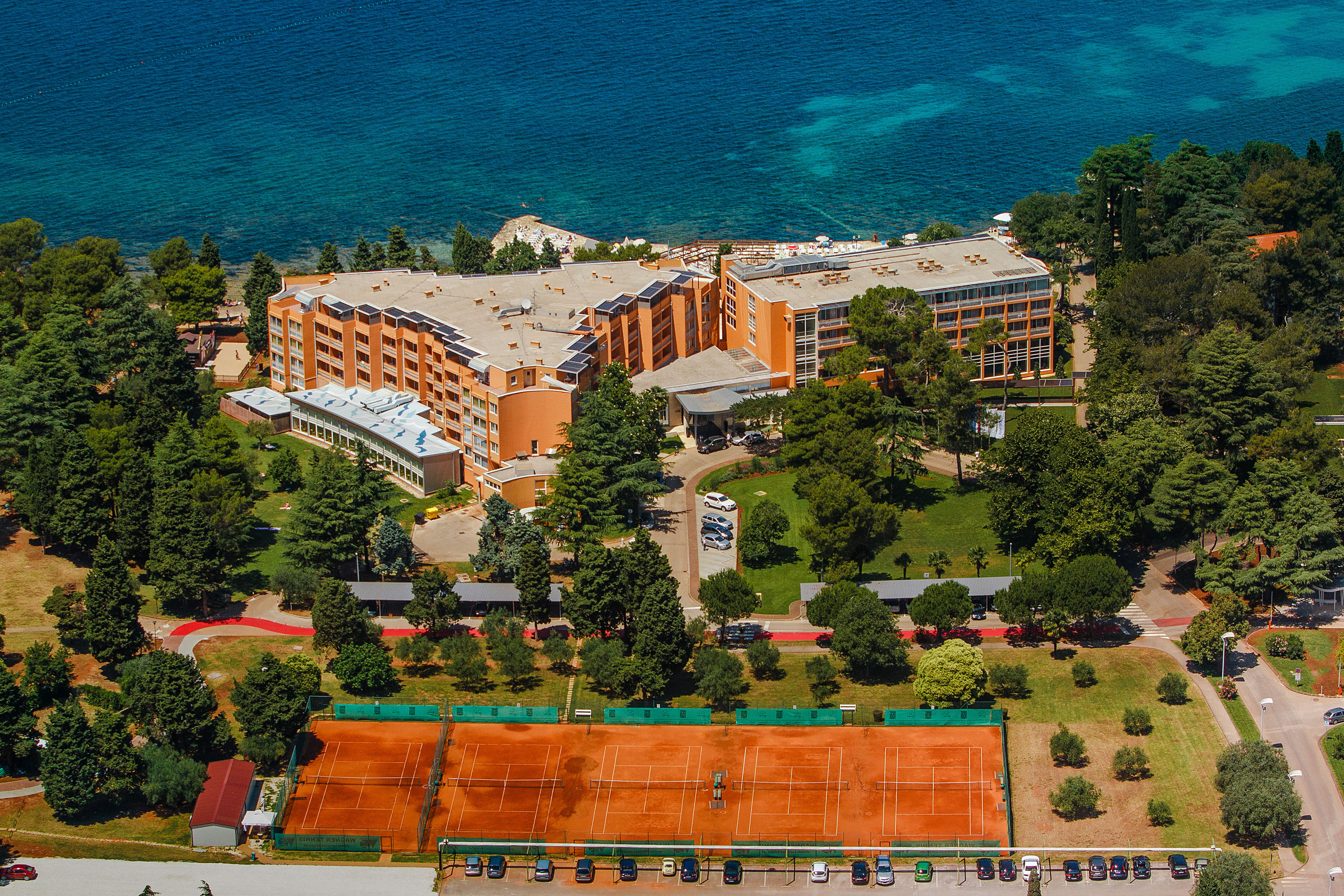 a tennis court and a building by the water