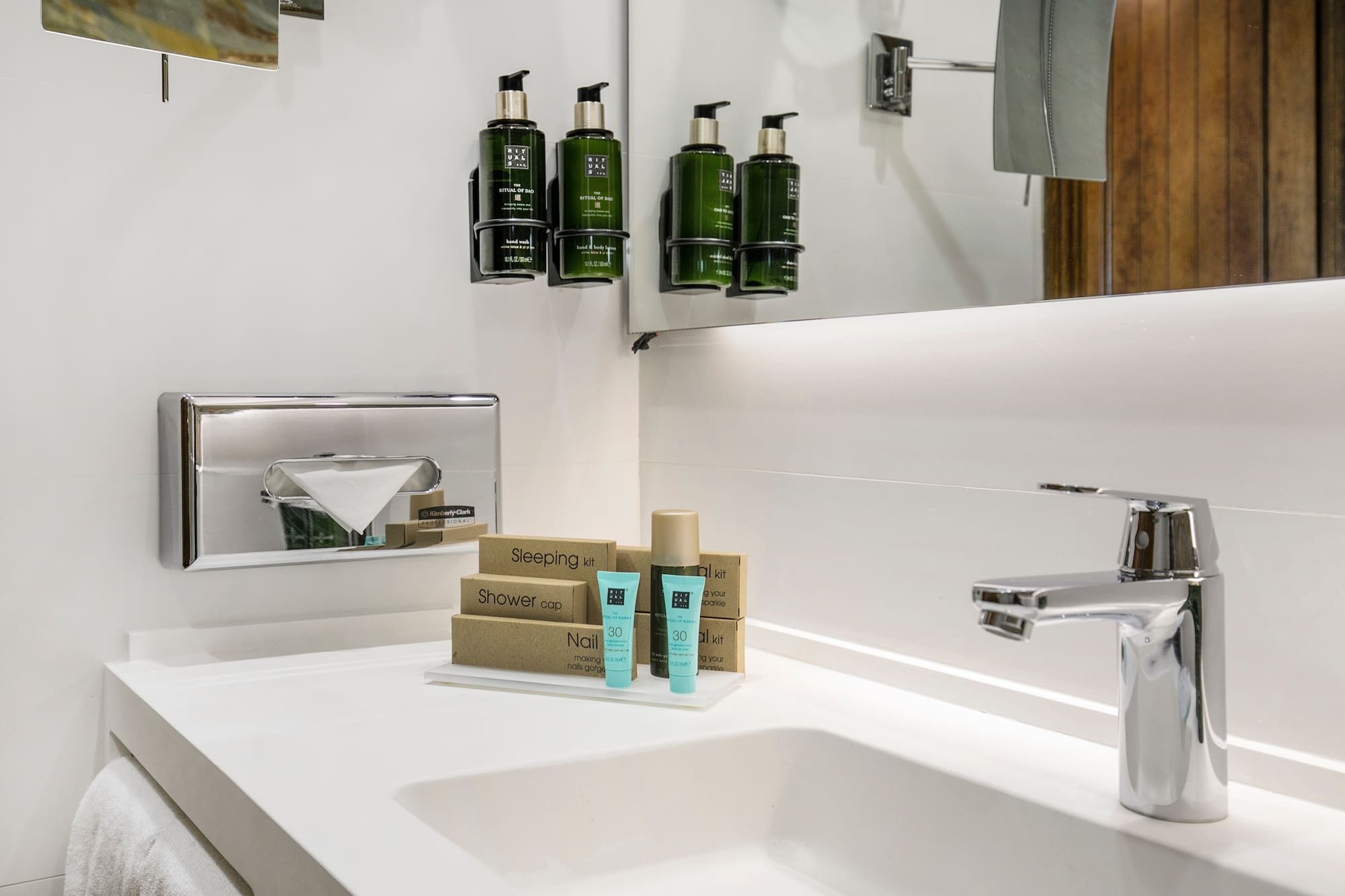 a bathroom sink with a mirror and a few bottles of shampoo