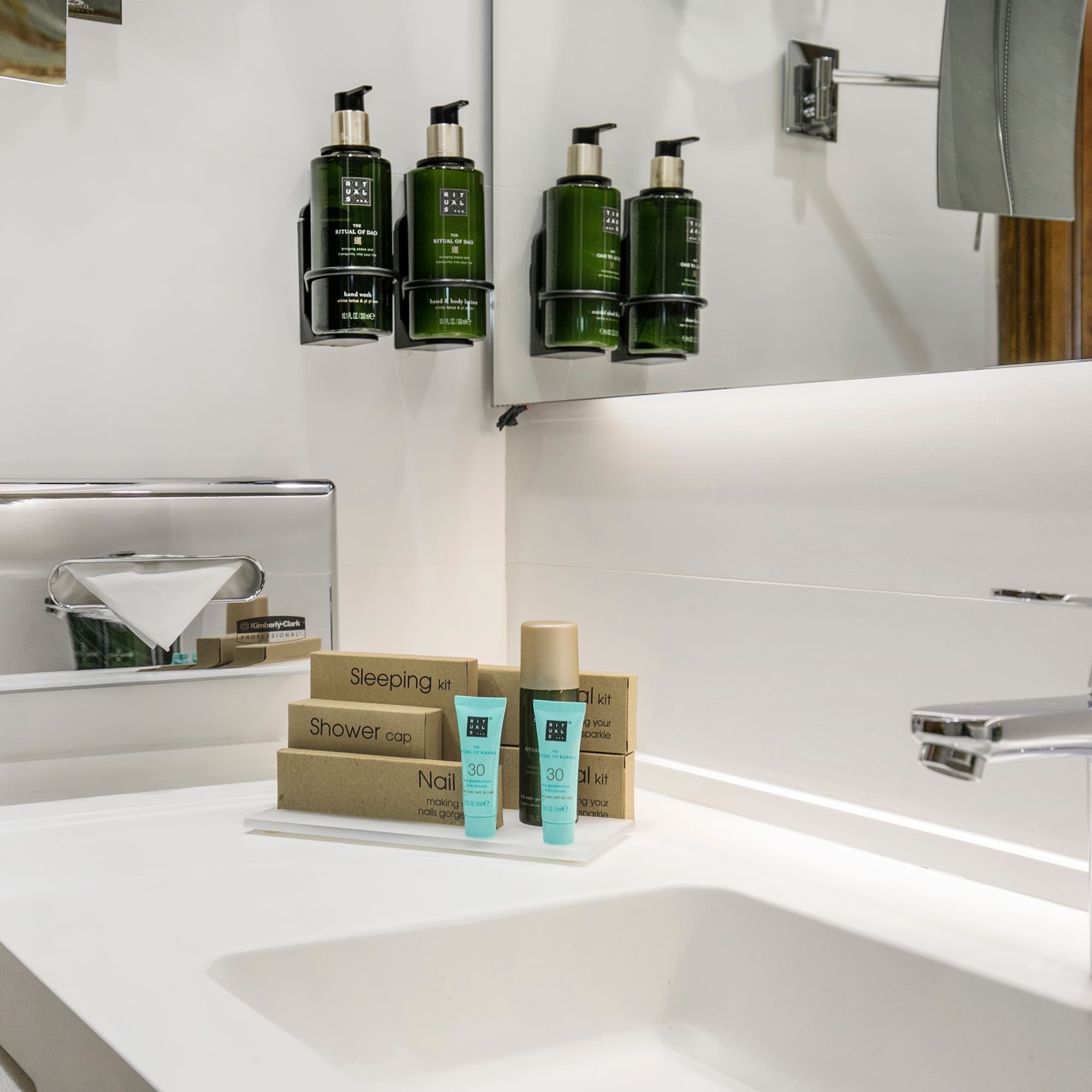 a bathroom sink with a mirror and a few bottles of shampoo