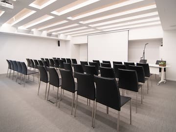 a room with chairs and a projector screen