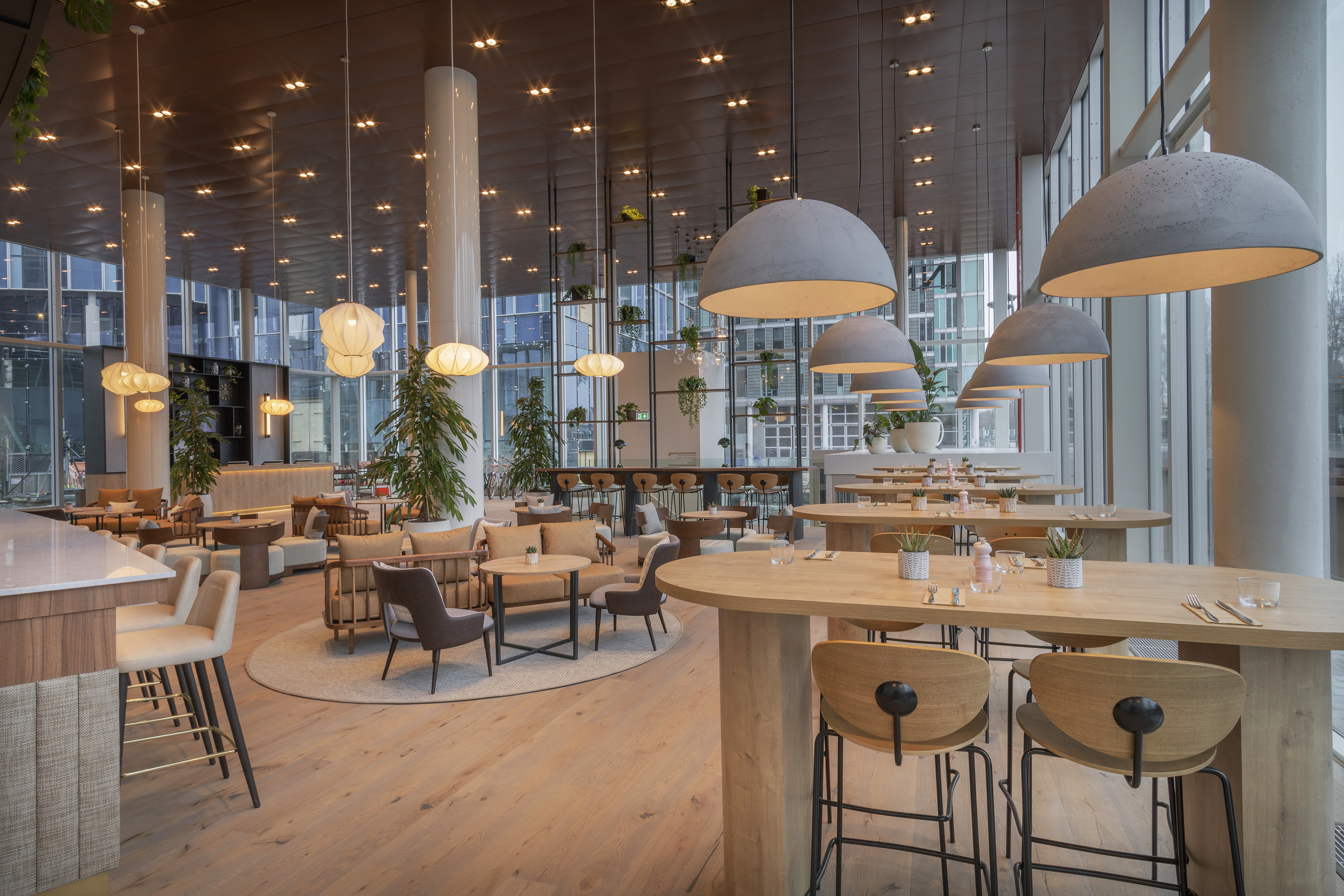 Stylish restaurant with wooden decor, lounge areas, and unique pendant lighting.
