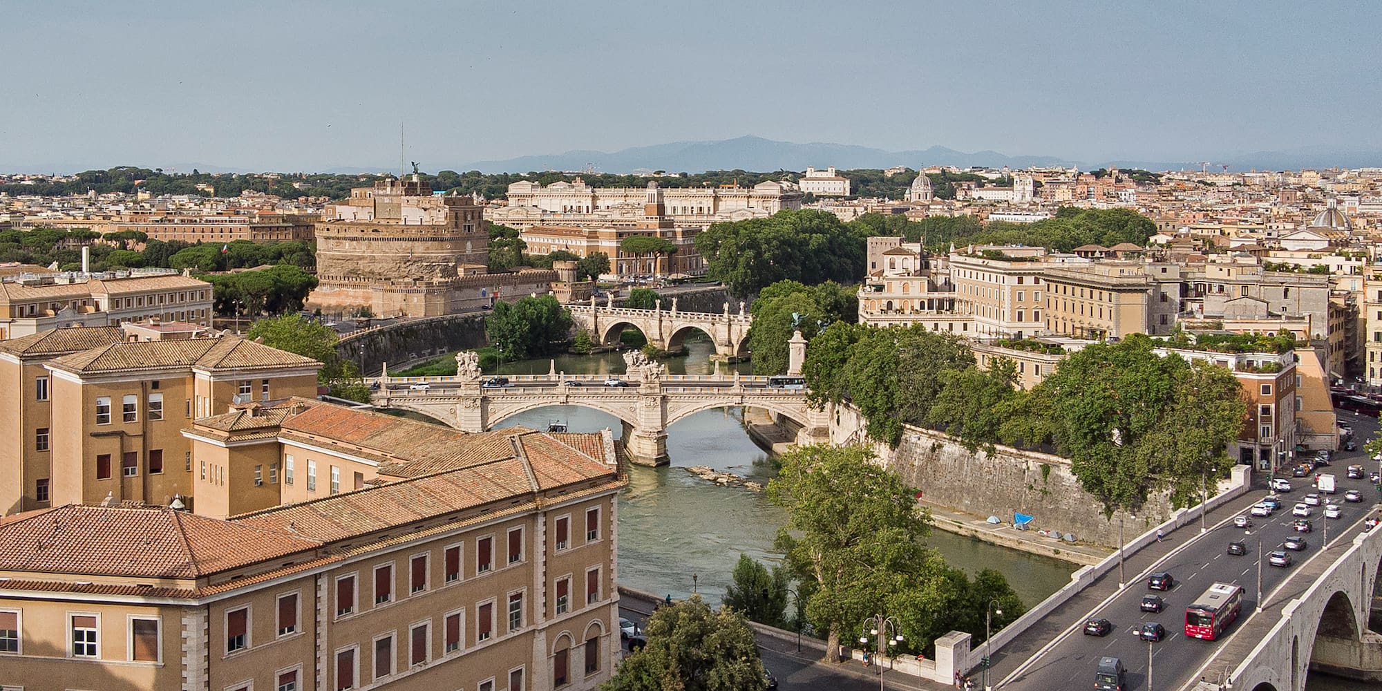 a bridge over a river with trees and buildings