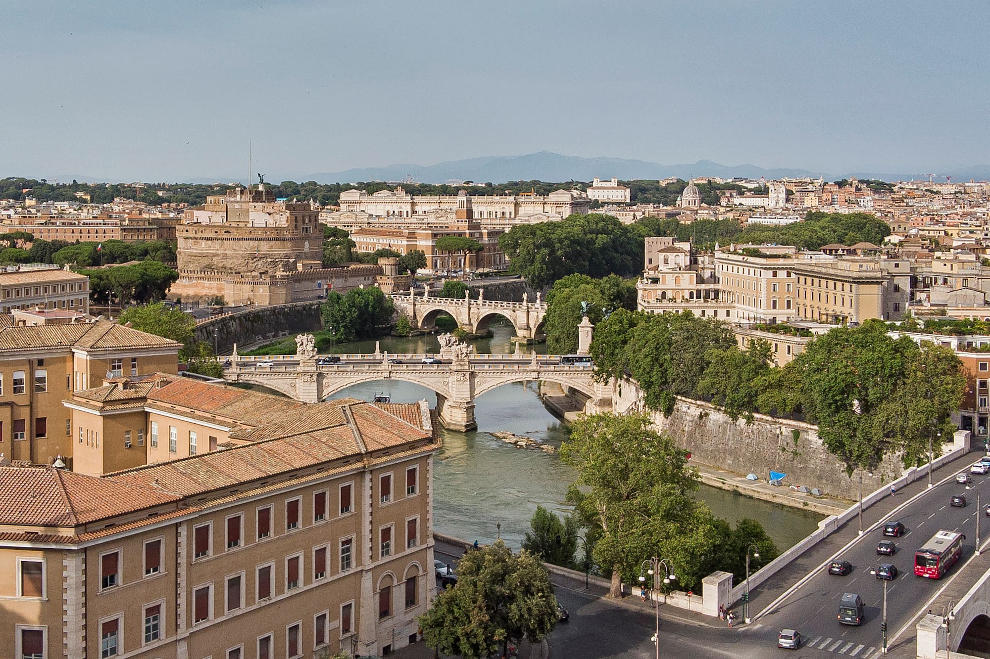 Iconic Rome cityscape: Castel Sant'Angelo, Tiber River, and historic bridges.