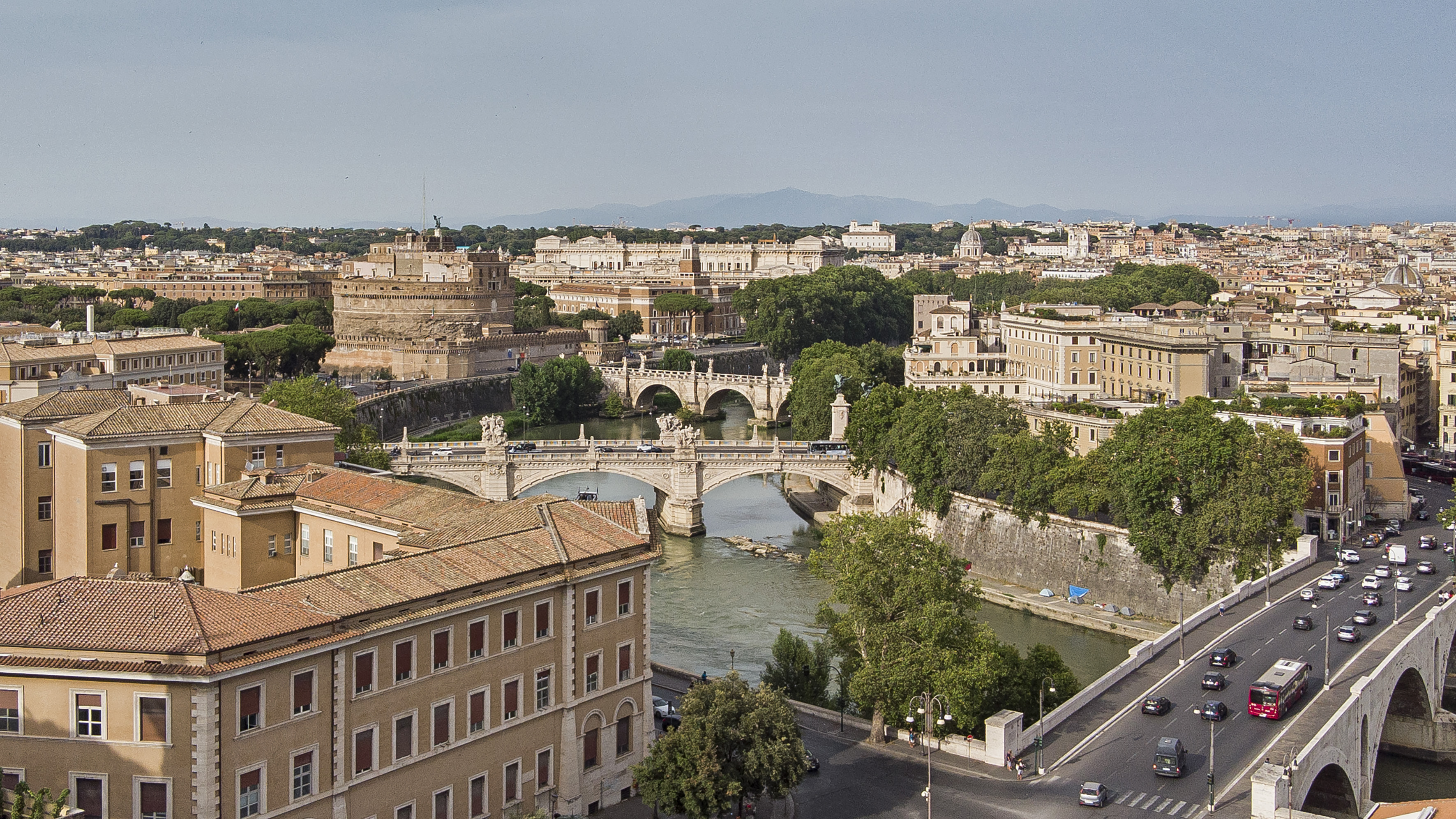Iconic Rome cityscape: Castel Sant'Angelo, Tiber River, and historic bridges.