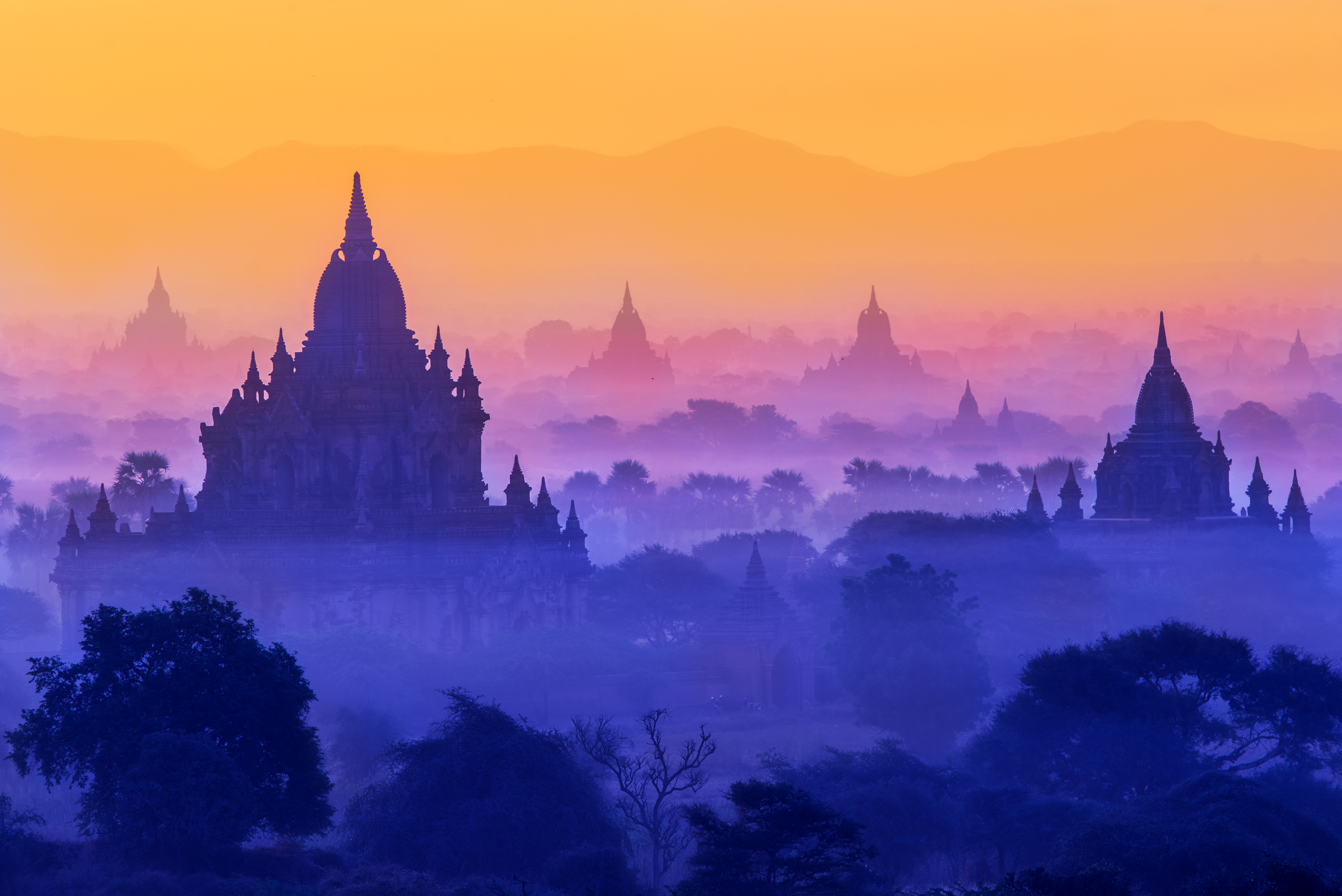 a landscape with a large building and trees