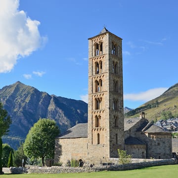 a stone building with a tower in front of a mountain