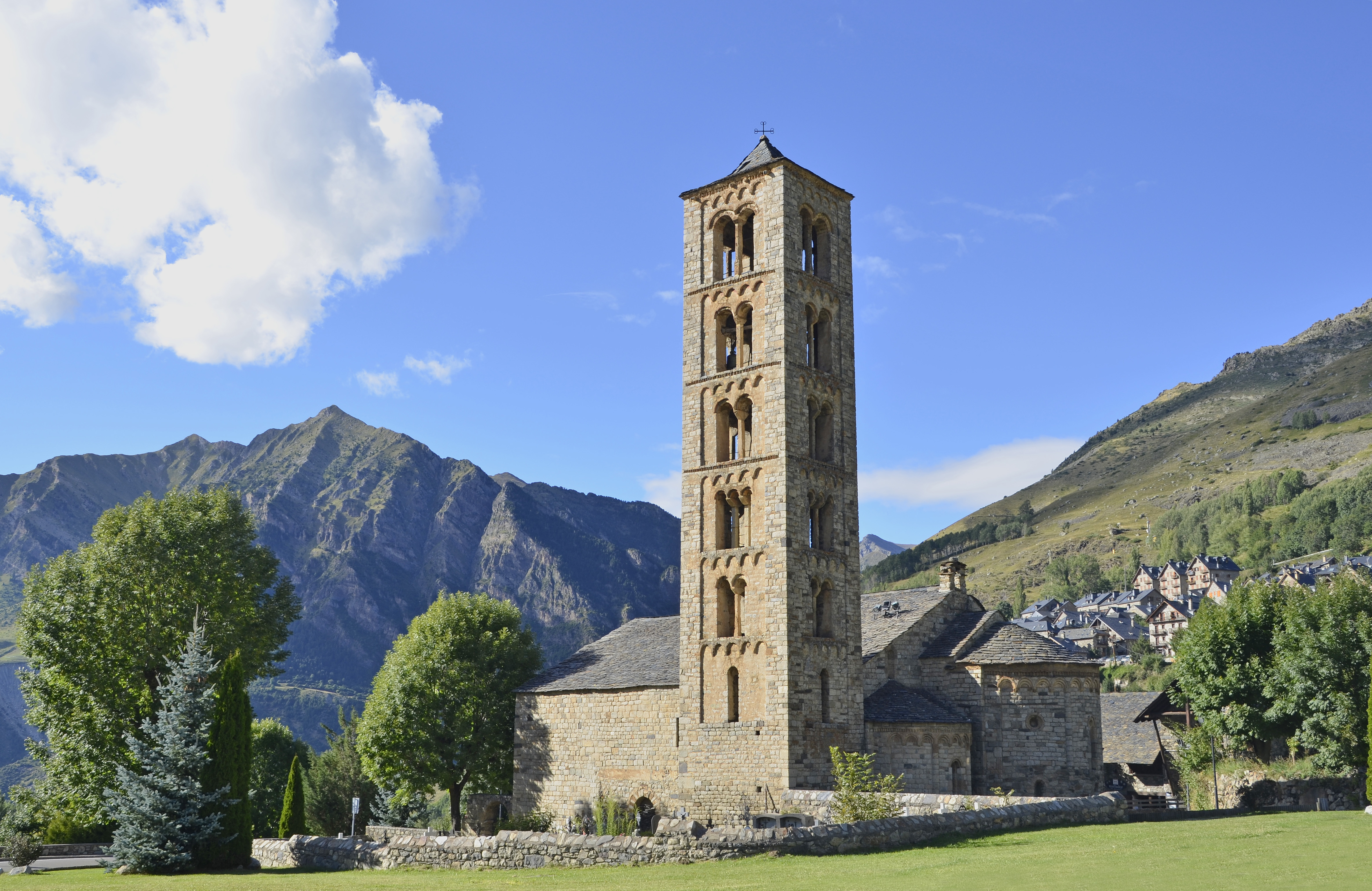 a stone building with a tower in front of a mountain