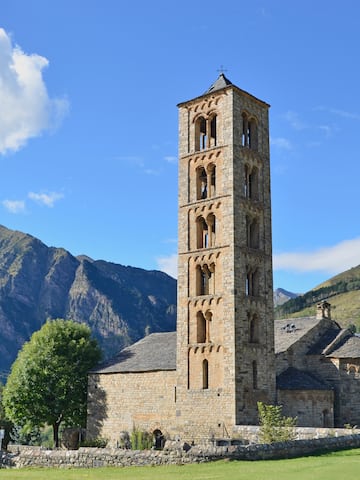 a stone building with a tower in front of a mountain