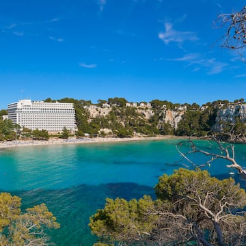 a body of water with trees and buildings in the background