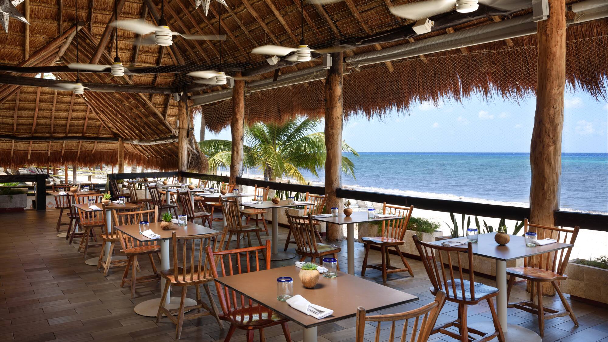 a restaurant with tables and chairs on a beach