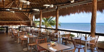 a restaurant with tables and chairs on a beach