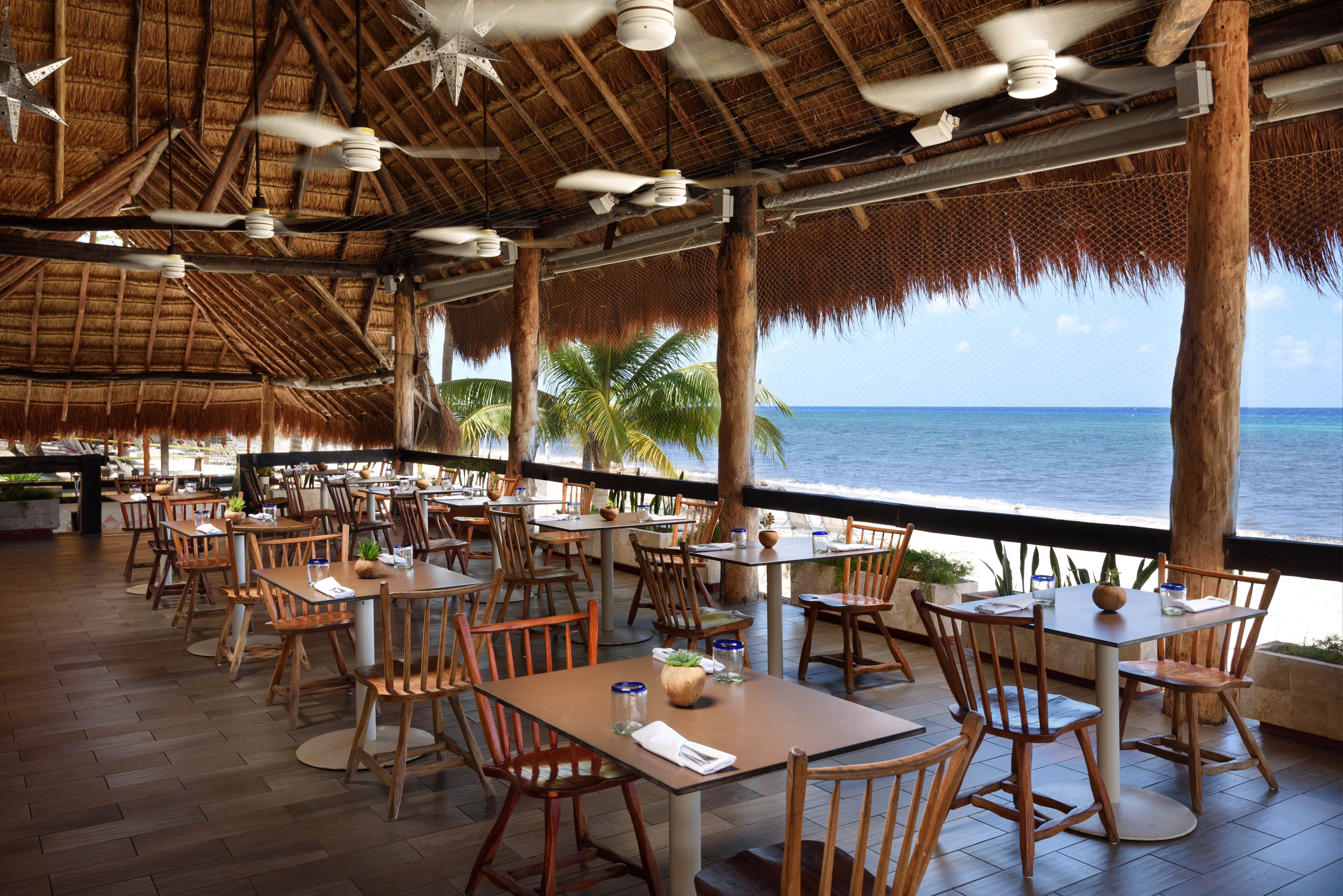 a restaurant with tables and chairs on a beach