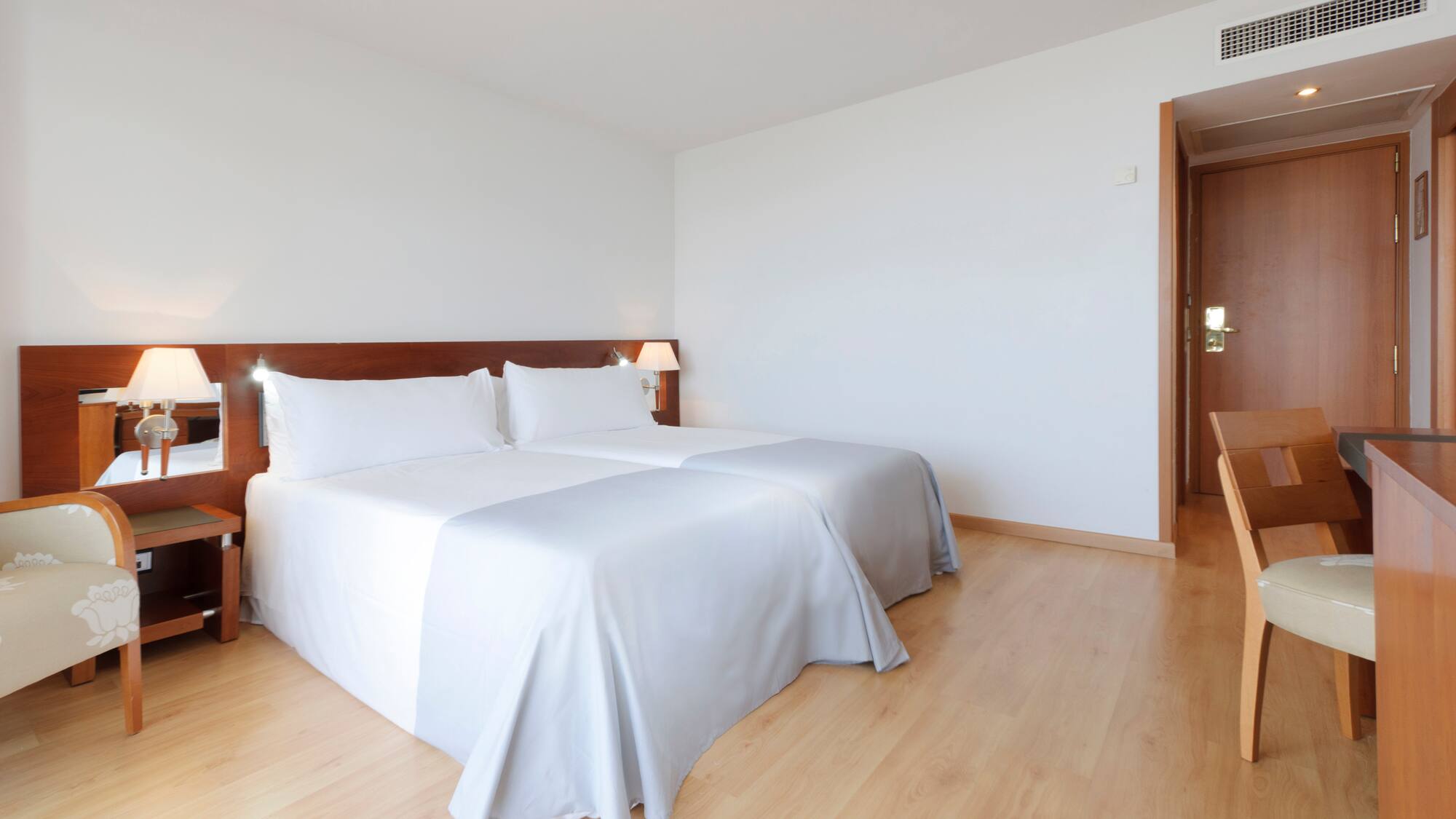 a room with two beds and a wood floor